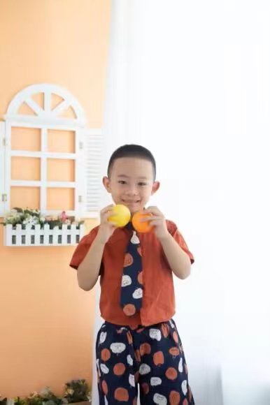 手捧橘子的微笑少年