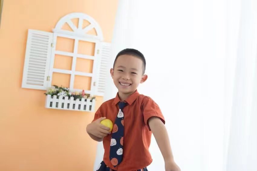 手捧橘子的微笑少年