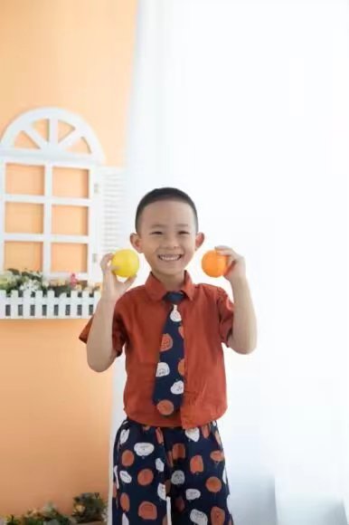 手捧橘子的微笑少年