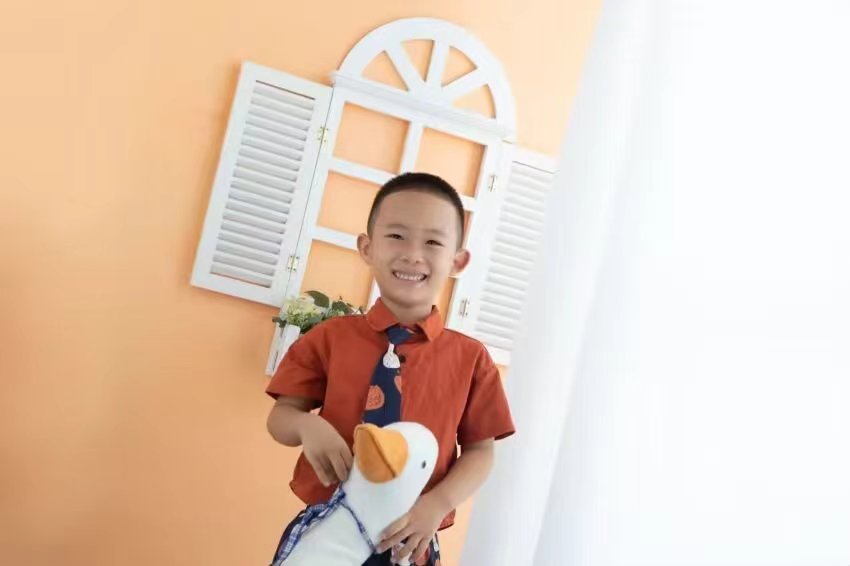 手捧橘子的微笑少年