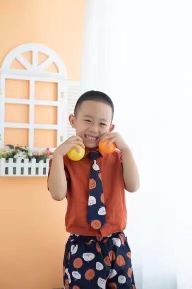 手捧橘子的微笑少年