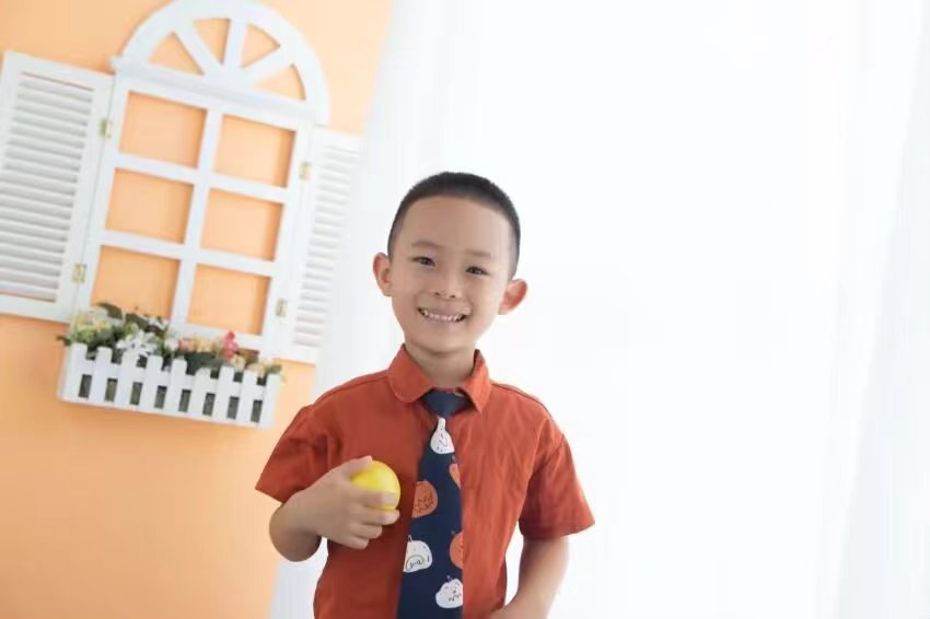 手捧橘子的微笑少年