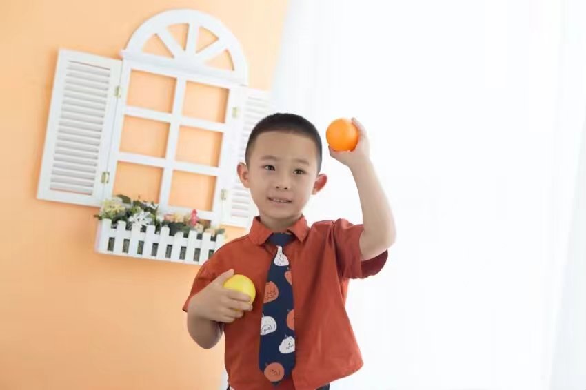 手捧橘子的微笑少年